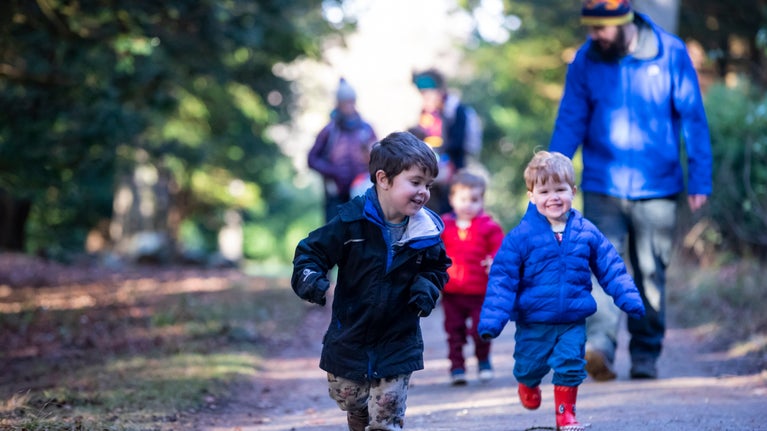 view of a young family walking in woods